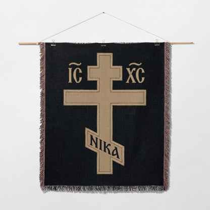 Cross with IC XC NIKA inscription on a black woven tapestry.