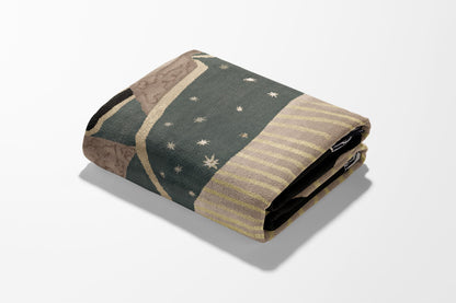 Folded patterned blanket with beige and dark green stripes and small star accents.