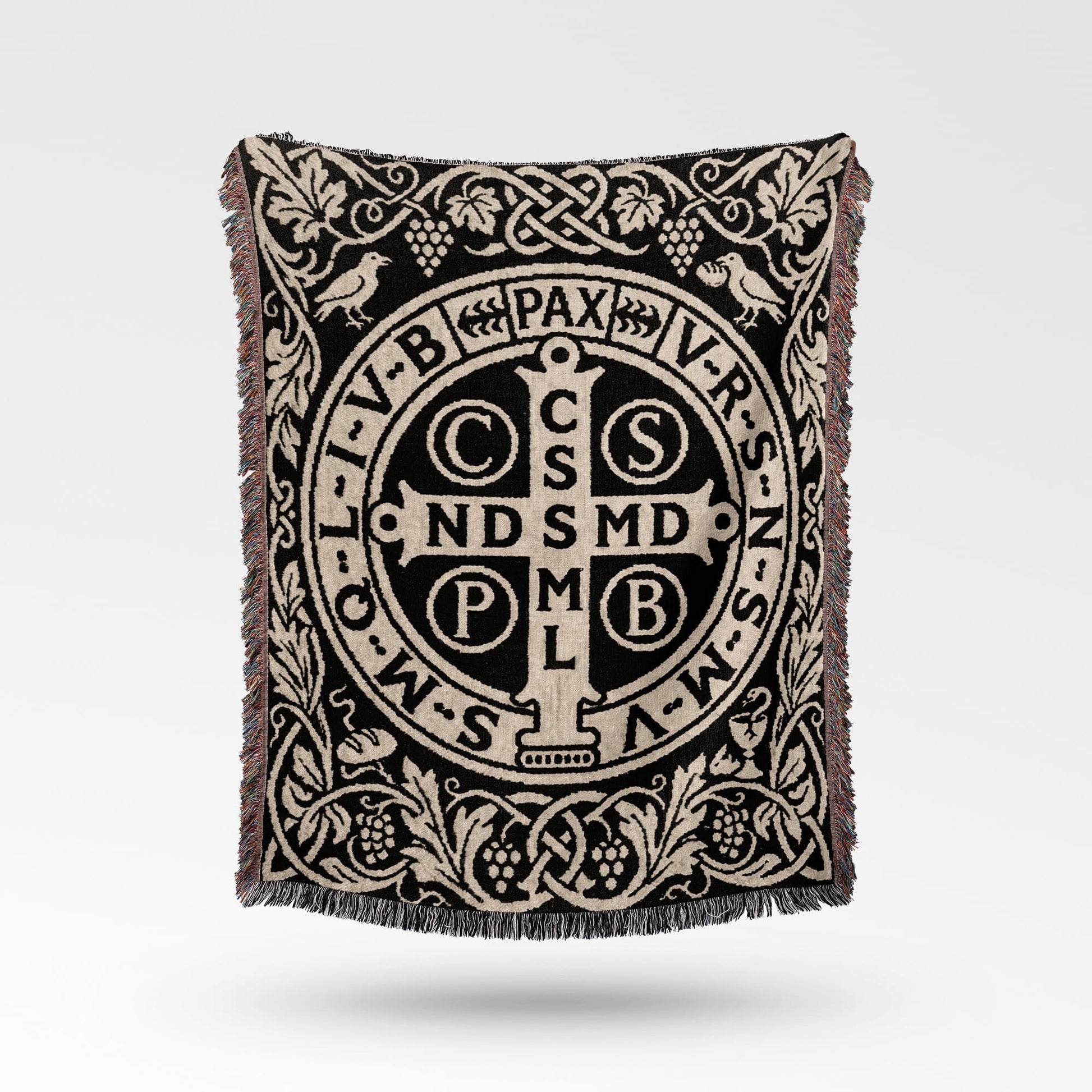 Black and beige woven throw blanket with Saint Benedict medal design and fringe.
