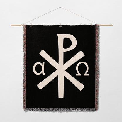 Black tapestry with white Chi-Rho symbol and alpha and omega.