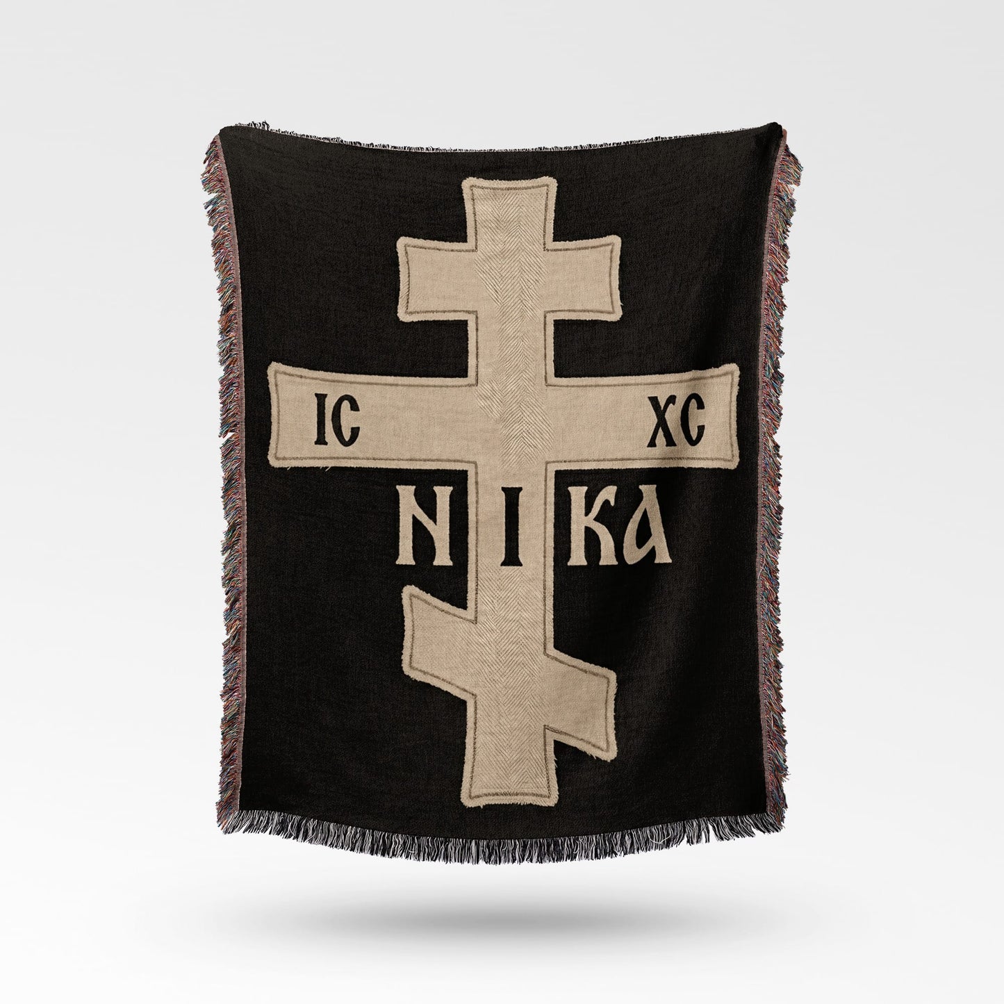 Black throw blanket with a beige Orthodox cross and "IC XC NIKA" inscription.