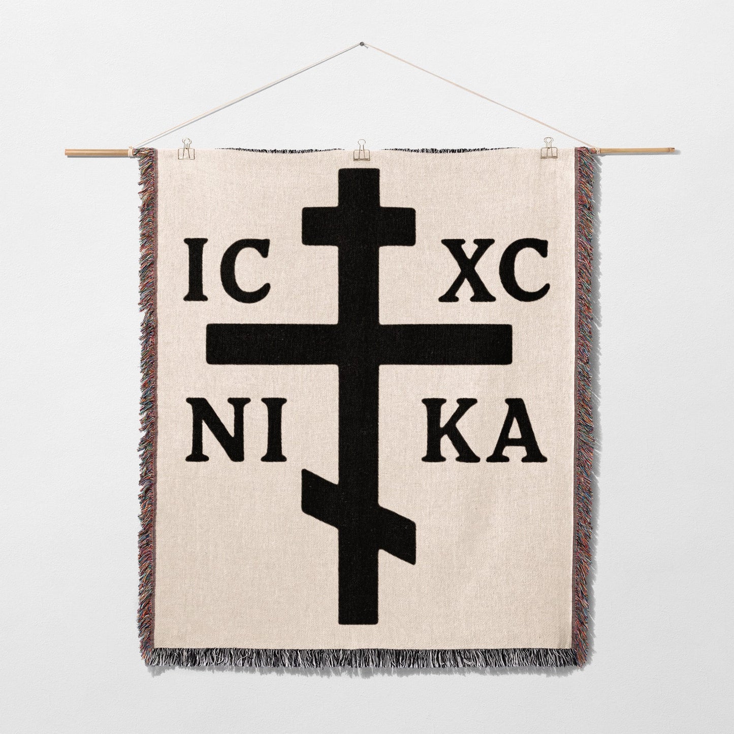 Orthodox Christian cross with IC XC NI KA inscription on a woven blanket.