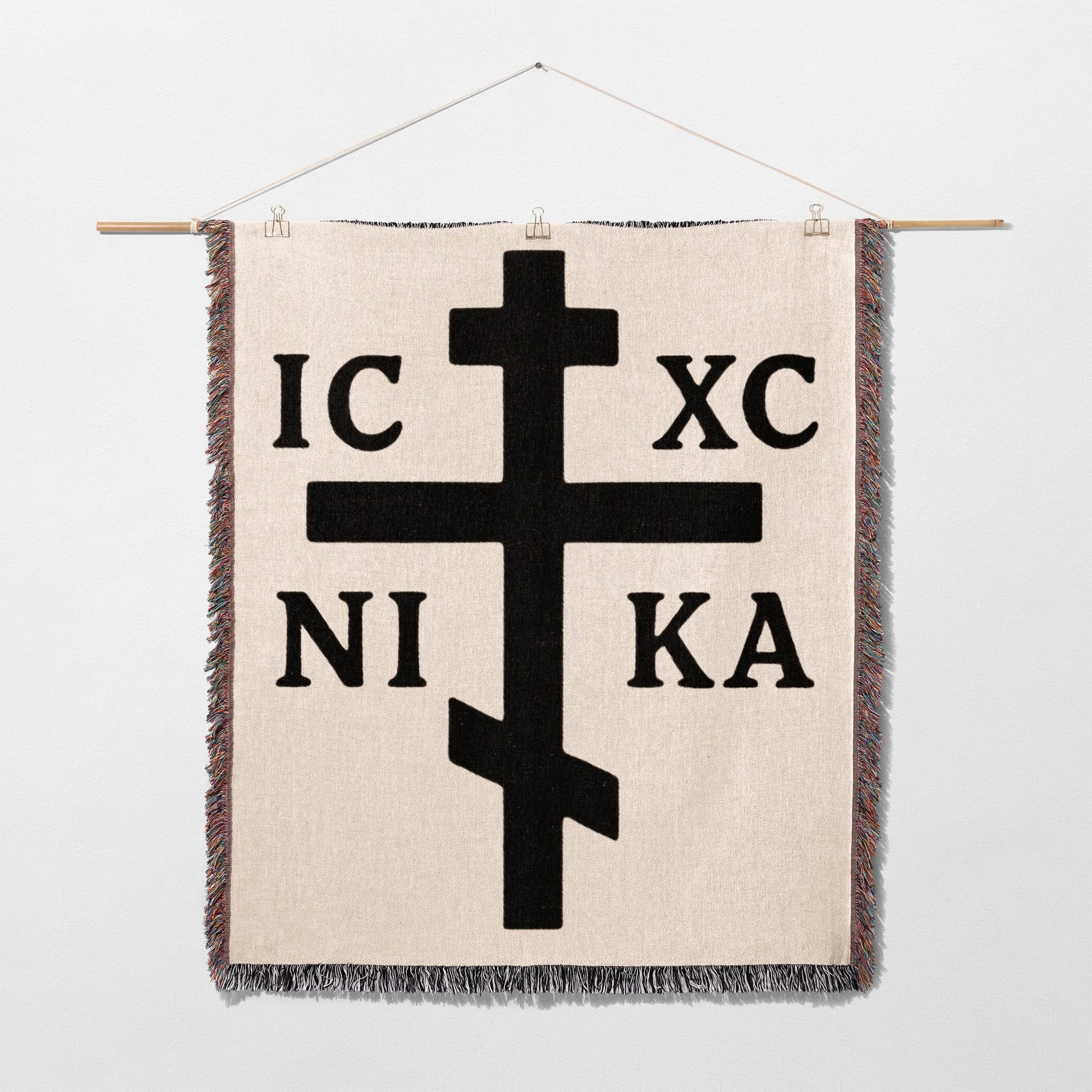 Orthodox Christian cross with IC XC NI KA inscription on a woven blanket.