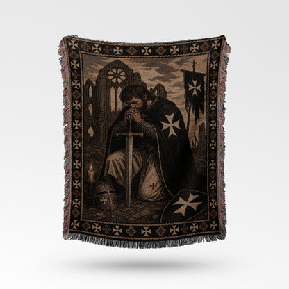 Kneeling knight in armor with sword on tapestry depicting castle and crosses.