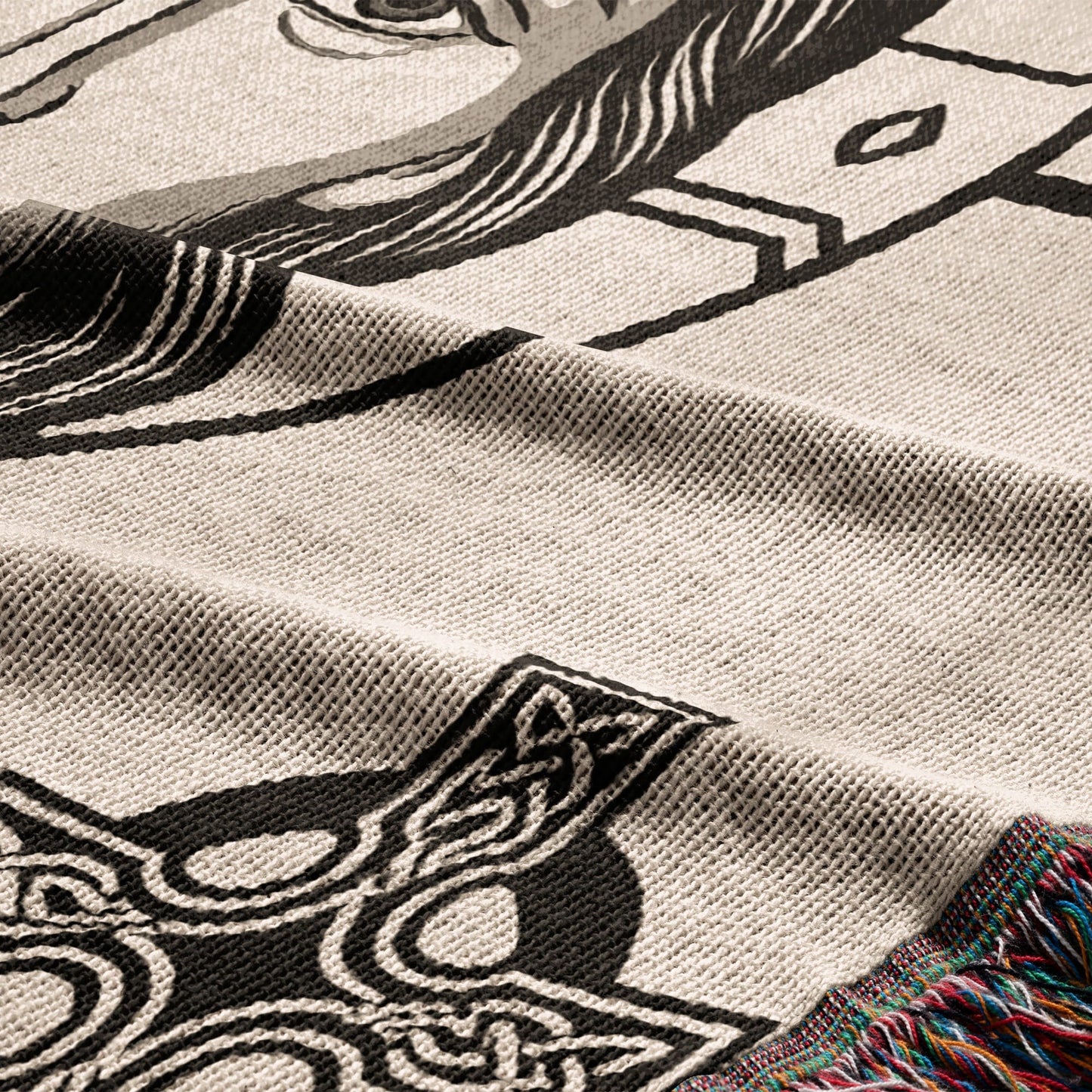 Woven blanket with intricate black and white Celtic knot and horse design.