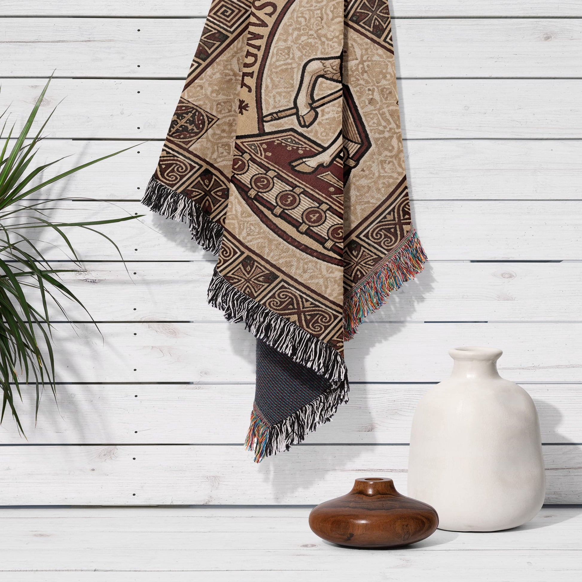 Textile tapestry with horse and chariot design hanging on wooden wall.