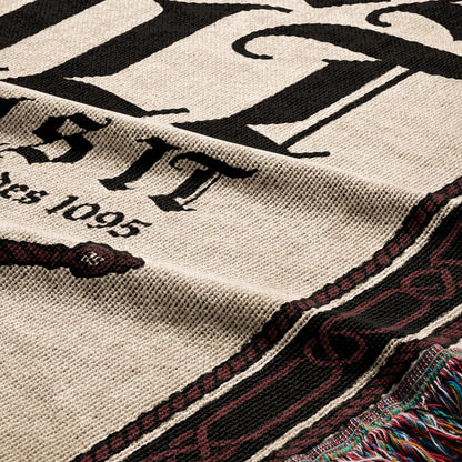 Close-up of a woven blanket with "ESTD 1095" and ornate border.