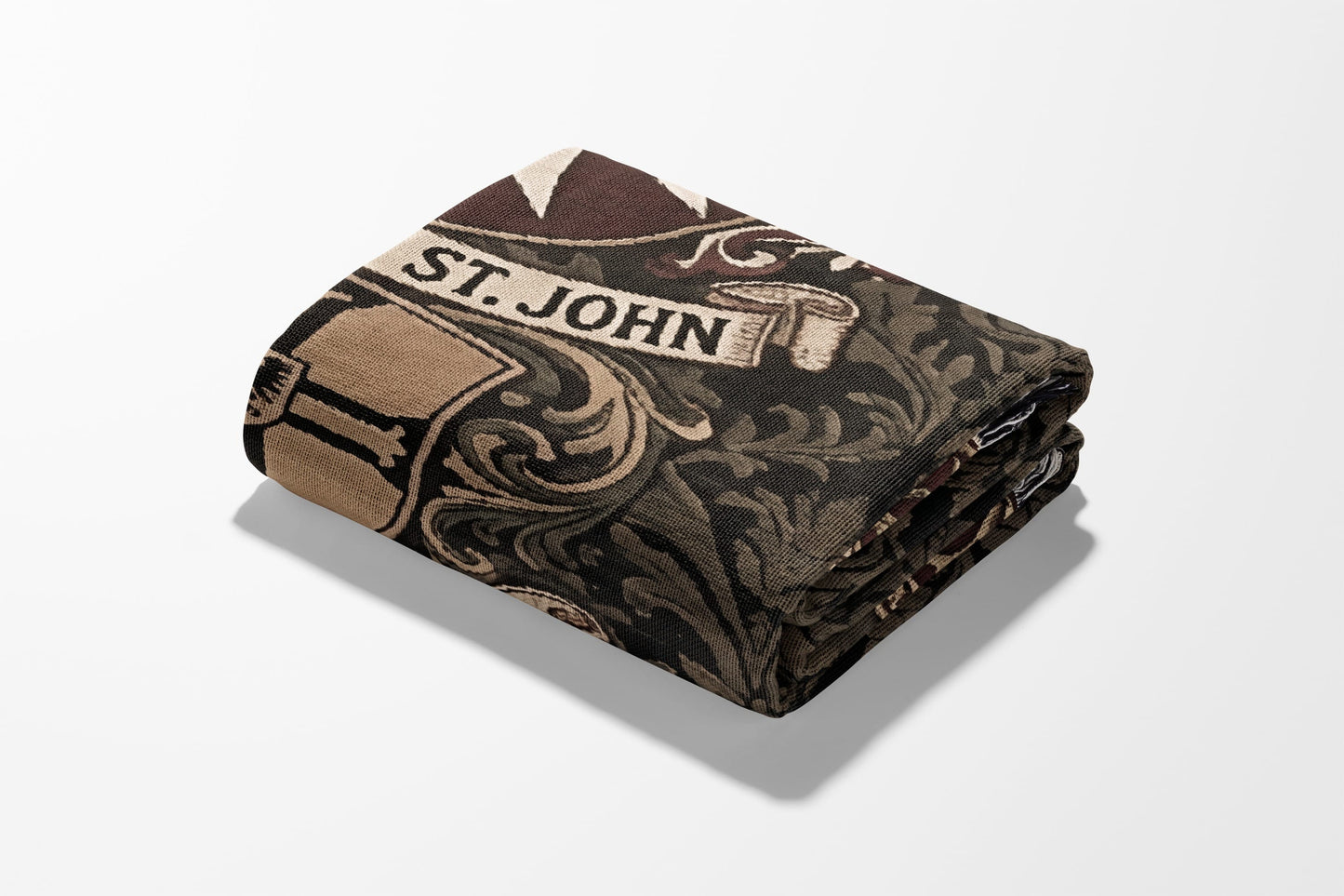 Folded tapestry with "ST. JOHN" text and an ornate scrollwork pattern in brown tones.