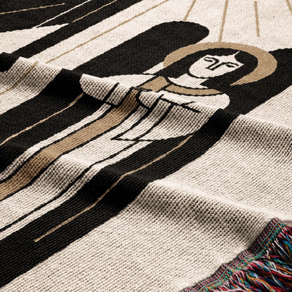 Woven blanket with a stylized angelic figure in black and tan on a cream background.