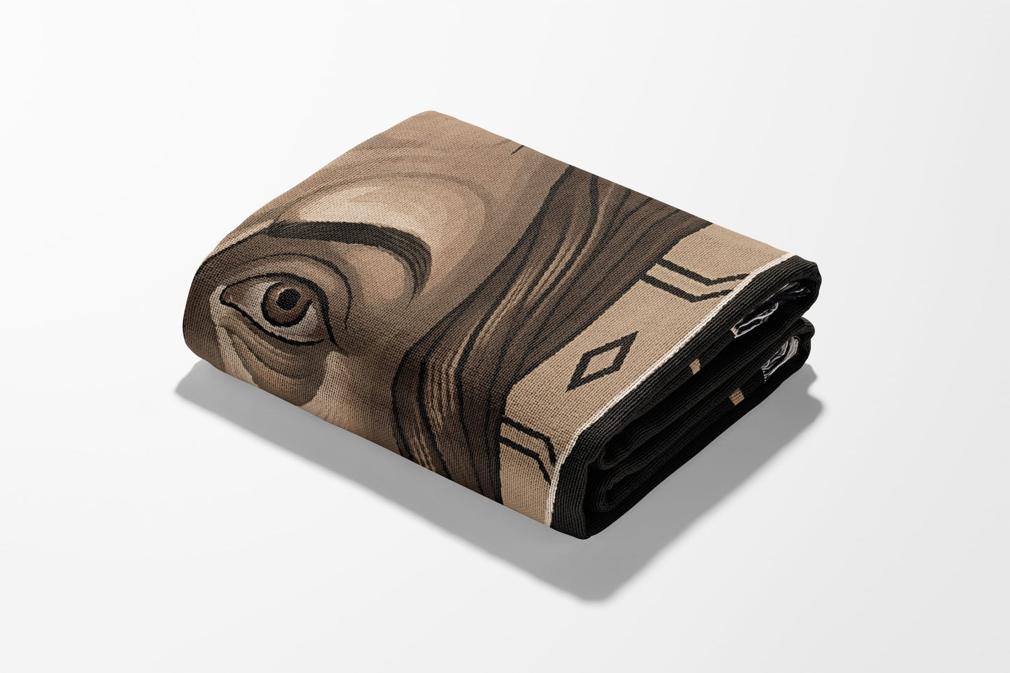 Folded blanket with a portrait of a person's eye and geometric border.